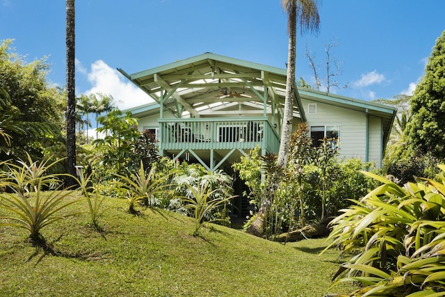 view of front of property with a ceiling fan and a front yard