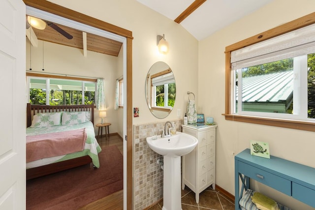 bathroom featuring ensuite bath, ceiling fan, tile patterned flooring, beam ceiling, and a sink