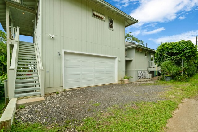 6450 Olohena Rd, Kapaa, HI 96746 - view of side of home with stairway, an attached garage, and driveway
