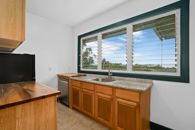6450 Olohena Rd, Kapaa, HI 96746 - kitchen with stainless steel dishwasher, a sink, butcher block countertops, black refrigerator, and light tile patterned floors