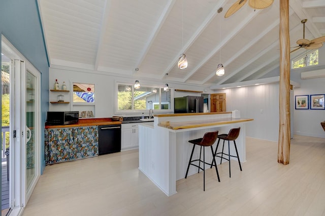 kitchen featuring vaulted ceiling with beams, white cabinetry, a kitchen breakfast bar, black appliances, and decorative light fixtures