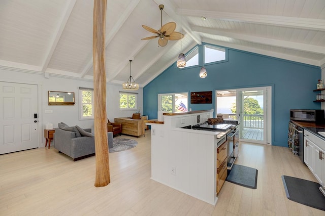 kitchen featuring stainless steel microwave, dark countertops, a wealth of natural light, and white cabinets