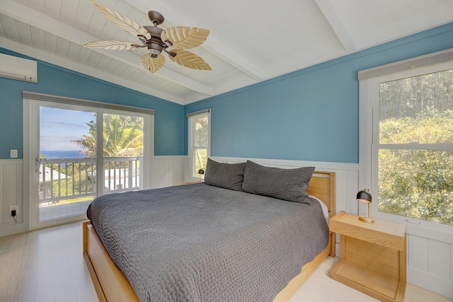 bedroom featuring lofted ceiling with beams, a wainscoted wall, access to exterior, an AC wall unit, and multiple windows