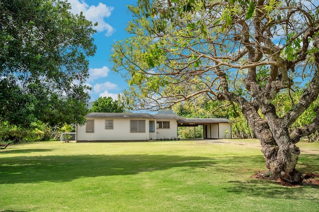 exterior space featuring an attached carport and a front yard