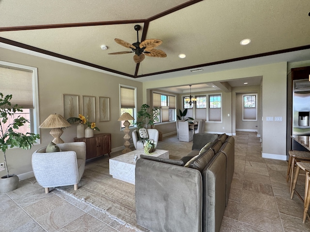 living area with visible vents, ceiling fan with notable chandelier, a tray ceiling, a textured ceiling, and baseboards