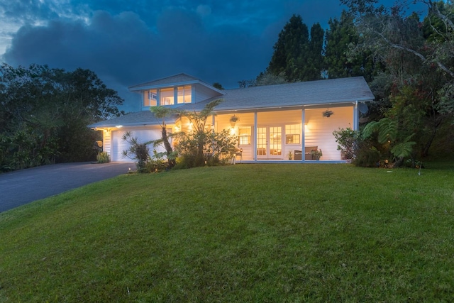 view of front of home with a front yard, french doors, and driveway