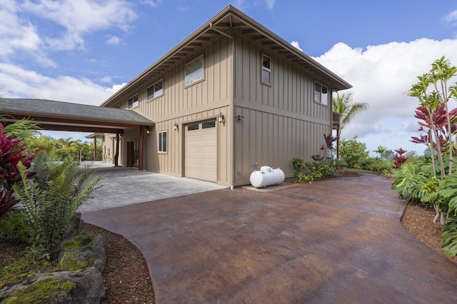 view of side of home featuring a garage, driveway, and board and batten siding