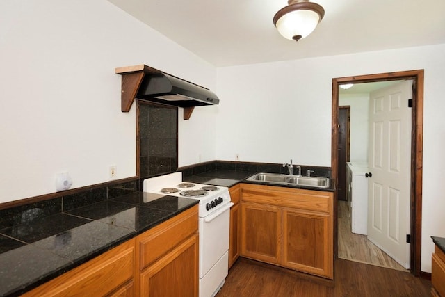 kitchen featuring electric stove, dark wood-type flooring, brown cabinetry, a sink, and under cabinet range hood