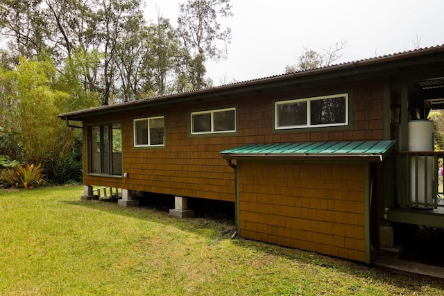 view of property exterior with metal roof and a yard