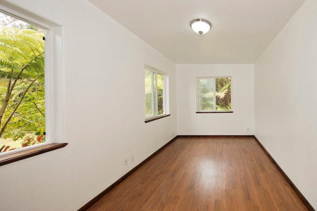 unfurnished room featuring baseboards and wood finished floors