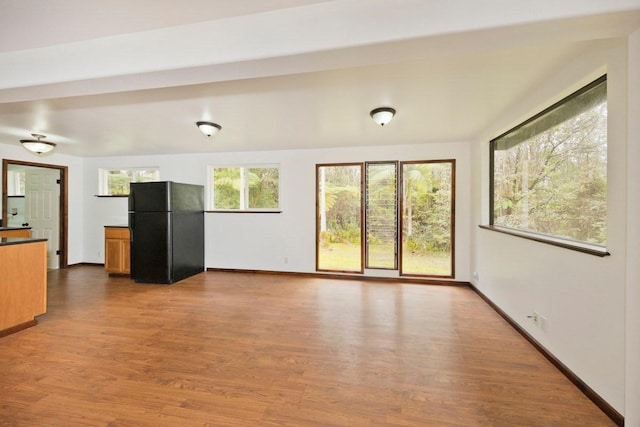 unfurnished living room featuring baseboards and wood finished floors