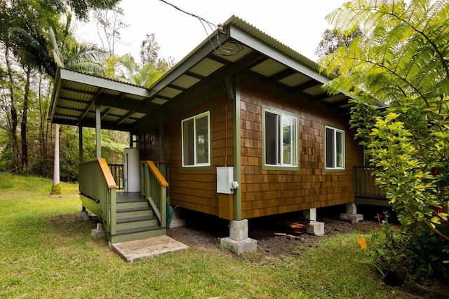 view of property exterior with water heater and a lawn