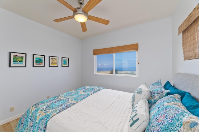 bedroom with ceiling fan, baseboards, and wood finished floors