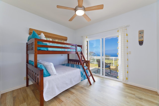 bedroom with access to outside, wood finished floors, a ceiling fan, and baseboards