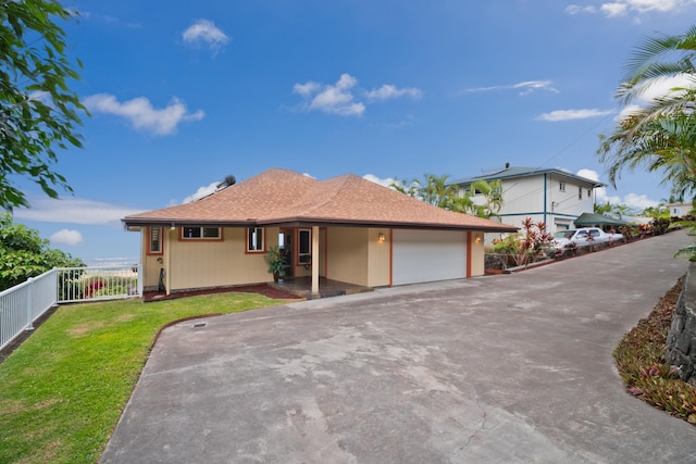 view of front of home featuring a shingled roof, concrete driveway, an attached garage, fence, and a front yard