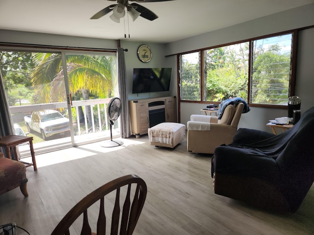 living room featuring light wood finished floors and a ceiling fan