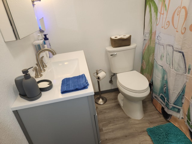 full bath featuring toilet, vanity, wood finished floors, a shower with curtain, and baseboards