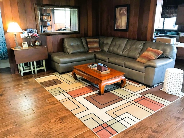 living area with wooden walls and wood finished floors