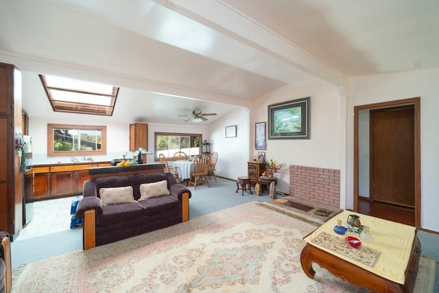 living area with lofted ceiling with beams, ceiling fan, and carpet flooring