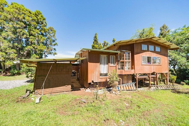 rear view of house featuring a lawn