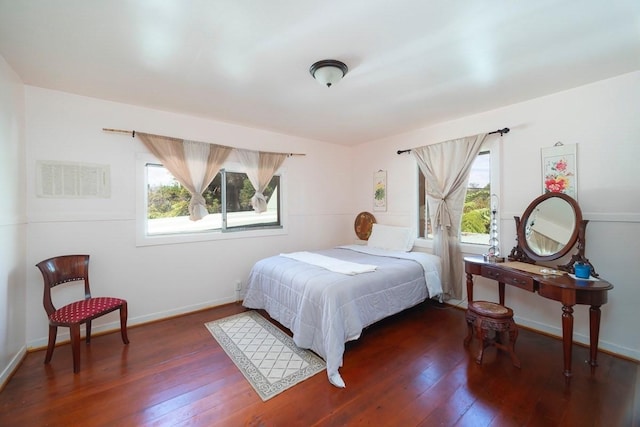 bedroom with dark wood-type flooring, multiple windows, and baseboards