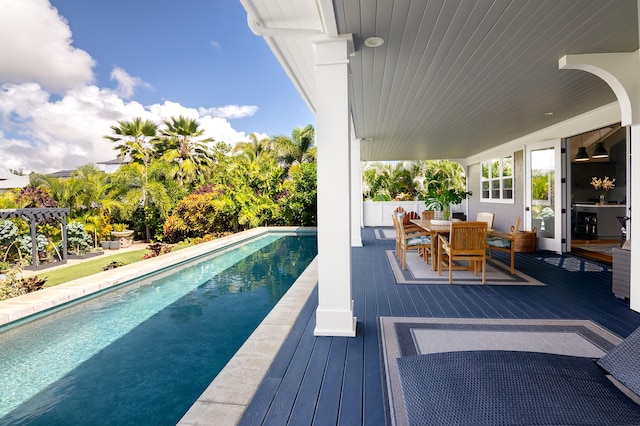 outdoor pool with a deck and outdoor dining area