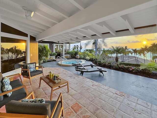 patio terrace at dusk featuring outdoor lounge area and a pool