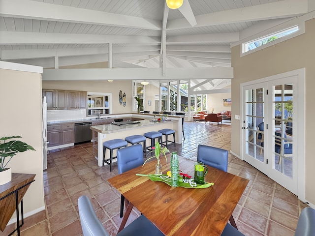 dining space with lofted ceiling with beams and french doors