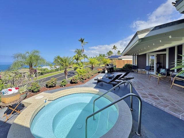 view of pool with area for grilling, an in ground hot tub, a patio, and fence