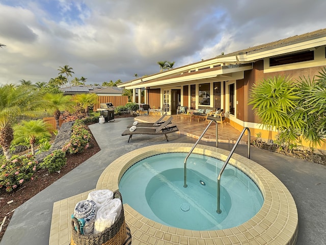 view of swimming pool with a patio, an in ground hot tub, and fence