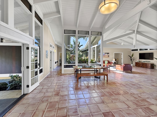 sunroom / solarium featuring lofted ceiling with beams and french doors