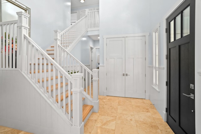 entrance foyer featuring a towering ceiling and stairs