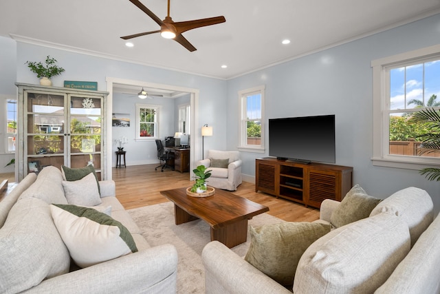 living area featuring light wood finished floors, baseboards, a ceiling fan, crown molding, and recessed lighting