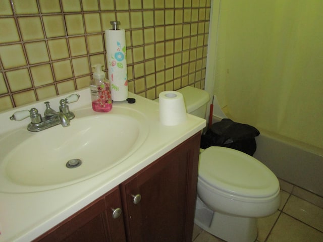 full bath with toilet, vanity, tile walls, tile patterned floors, and tasteful backsplash