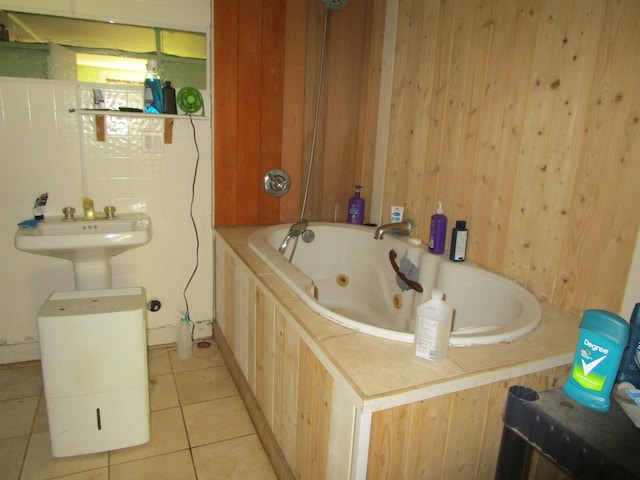 bathroom with tile patterned flooring, wooden walls, and a whirlpool tub