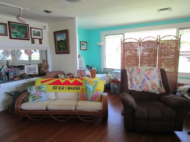 living area featuring visible vents and wood finished floors