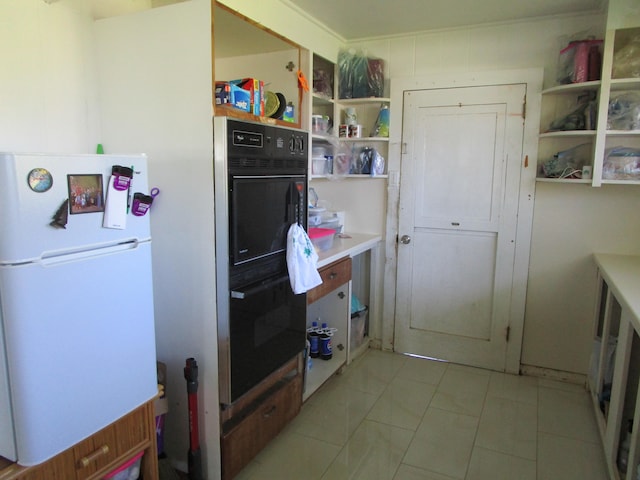 kitchen with freestanding refrigerator, dobule oven black, light tile patterned flooring, and open shelves