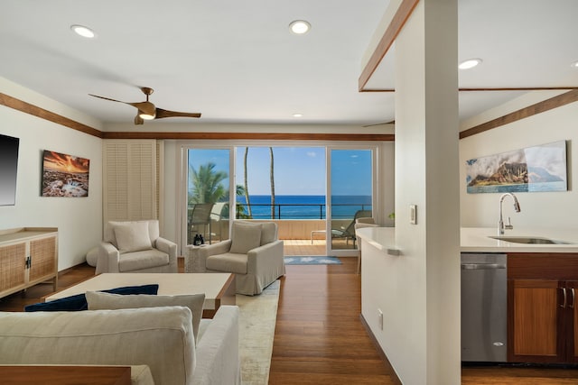 living room featuring a water view, a ceiling fan, wood finished floors, and recessed lighting