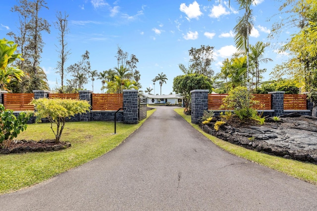 view of gate featuring a lawn and fence