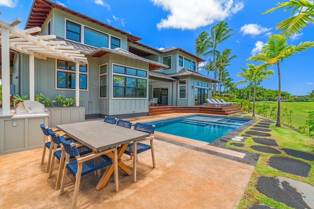 outdoor pool with a patio area, fence, exterior kitchen, and outdoor dining space