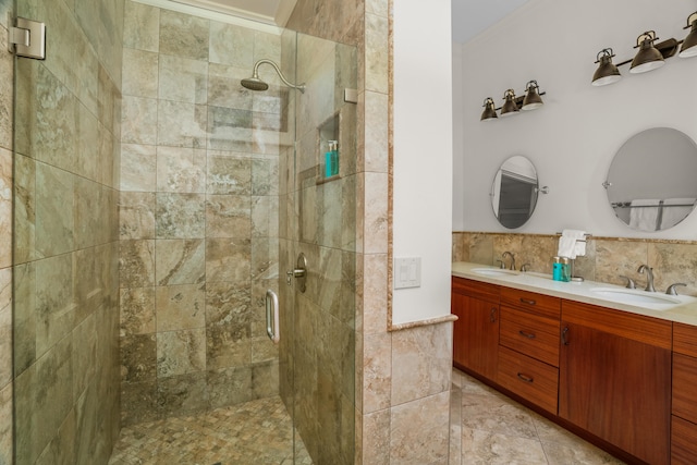 bathroom with double vanity, a shower stall, tile walls, and a sink