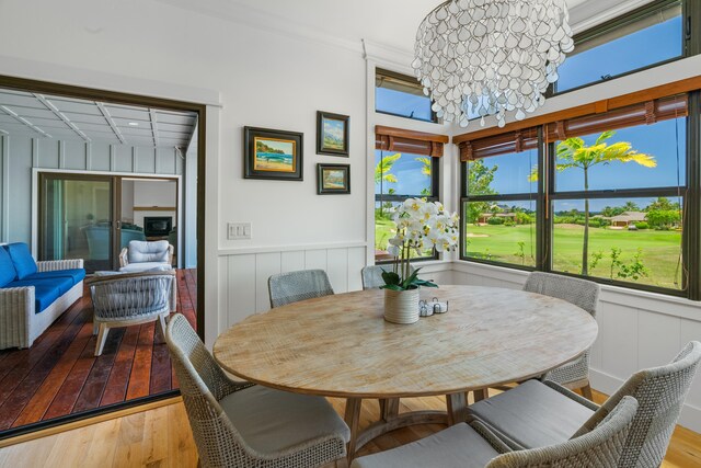 dining space featuring a wealth of natural light, an inviting chandelier, and wood finished floors