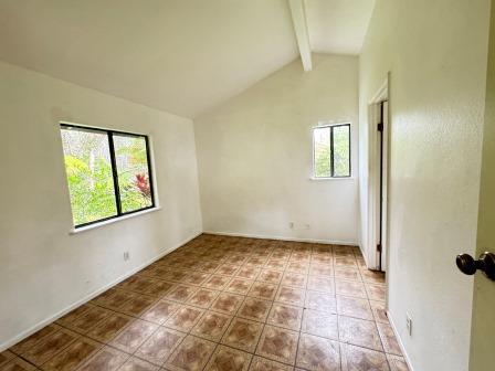 unfurnished room featuring vaulted ceiling with beams