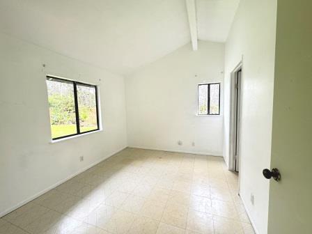 unfurnished room with lofted ceiling with beams and light floors