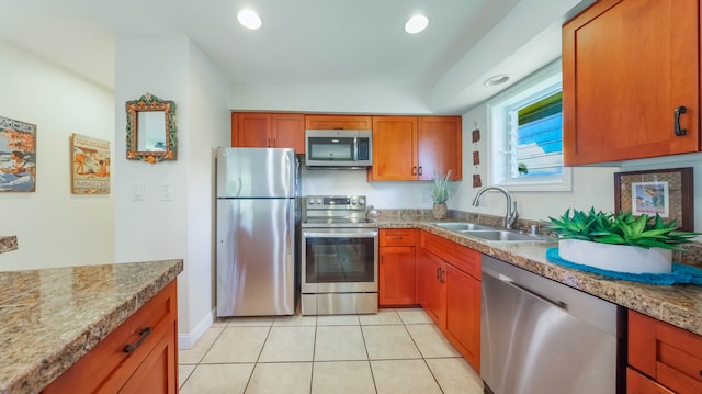 kitchen with stainless steel appliances, recessed lighting, a sink, and brown cabinets