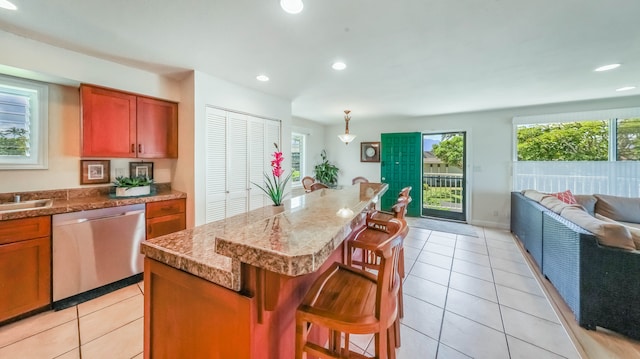 kitchen featuring light tile patterned floors, dishwasher, a breakfast bar area, open floor plan, and recessed lighting