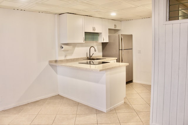 kitchen with baseboards, light tile patterned floors, freestanding refrigerator, white cabinets, and an ornate ceiling