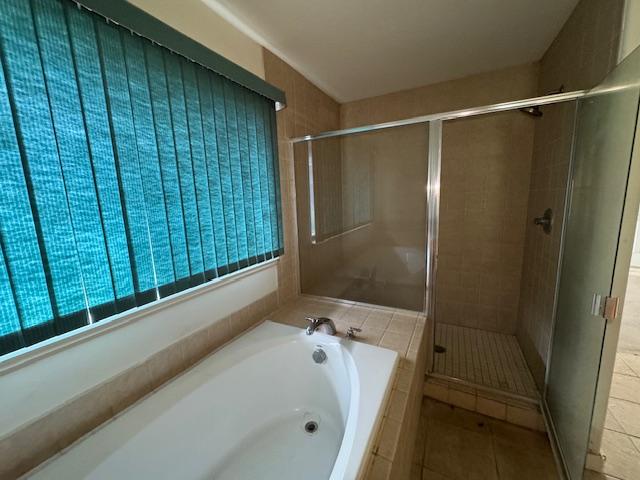 full bathroom featuring a stall shower, a garden tub, and tile patterned floors