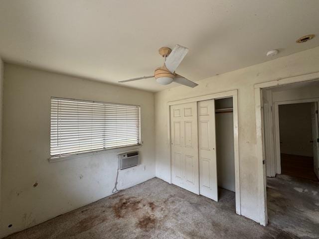 unfurnished bedroom with carpet floors, a ceiling fan, a closet, and a wall mounted AC