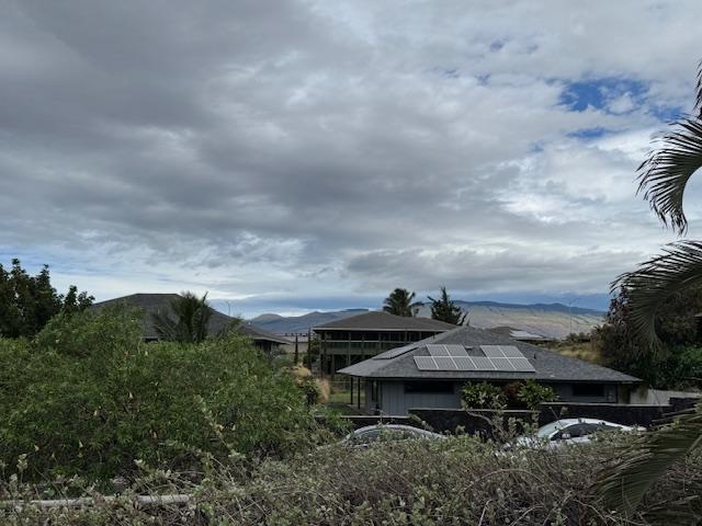 view of side of property featuring roof mounted solar panels and a mountain view